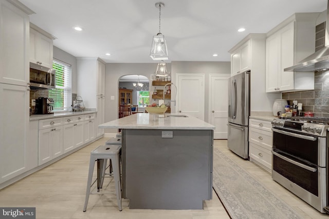 2914 6th St S, Arlington, VA 22204 - kitchen with appliances with stainless steel finishes, wall chimney range hood, arched walkways, tasteful backsplash, and recessed lighting