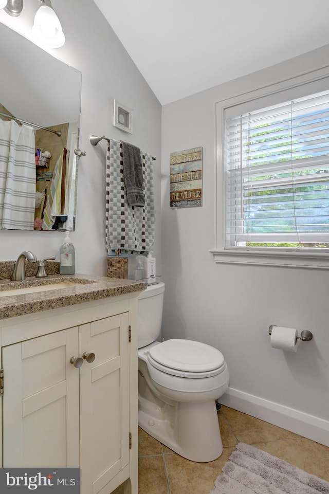 2914 6th St S, Arlington, VA 22204 - bathroom with tile patterned floors, toilet, vaulted ceiling, vanity, and baseboards