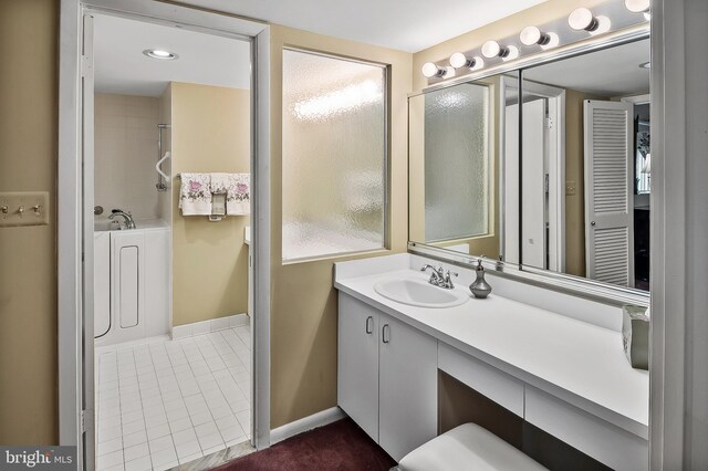 2 High Stepper Ct Unit 201, Baltimore, MD 21208 - full bathroom with vanity, a tub to relax in, baseboards, and tile patterned floors