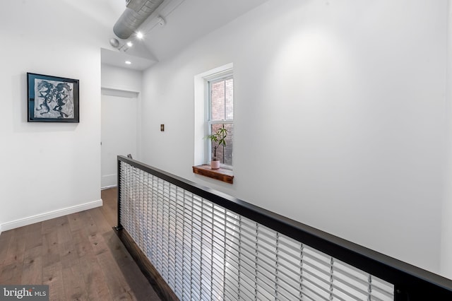 hallway featuring wood finished floors, baseboards, and recessed lighting