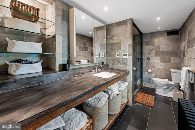 bathroom featuring tile walls, toilet, a stall shower, tile patterned floors, and recessed lighting