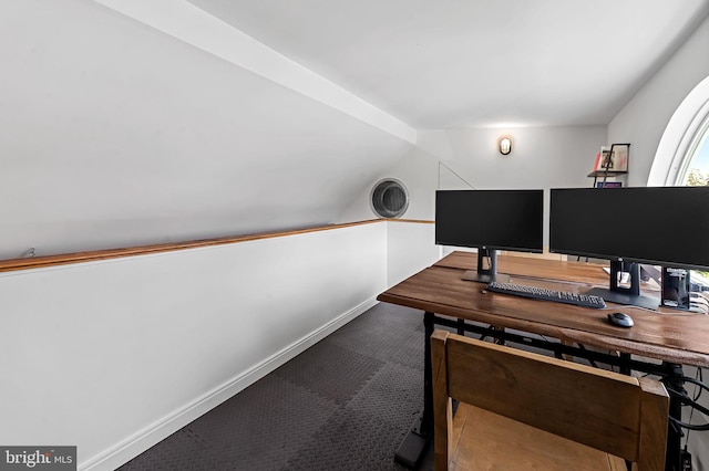carpeted home office with baseboards and lofted ceiling
