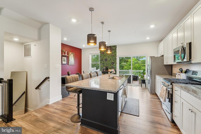 7853 Bluelick Run Rd, Baltimore, MD 21244 - kitchen with stainless steel appliances, an island with sink, recessed lighting, a breakfast bar, and white cabinets