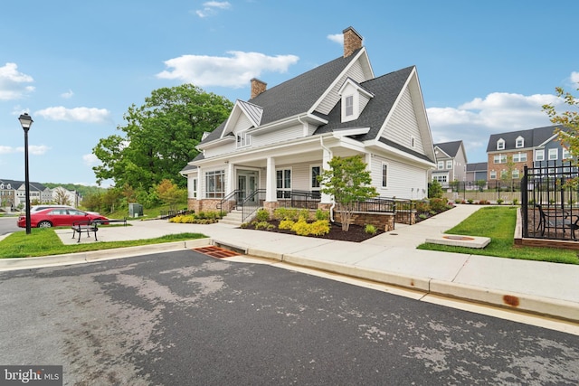 7853 Bluelick Run Rd, Baltimore, MD 21244 - view of front of home with a chimney, covered porch, a shingled roof, and a residential view