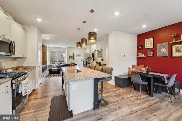 7853 Bluelick Run Rd, Baltimore, MD 21244 - kitchen with stainless steel appliances, a sink, open floor plan, light wood finished floors, and recessed lighting