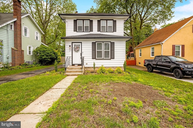 traditional style home featuring cooling unit and a front lawn