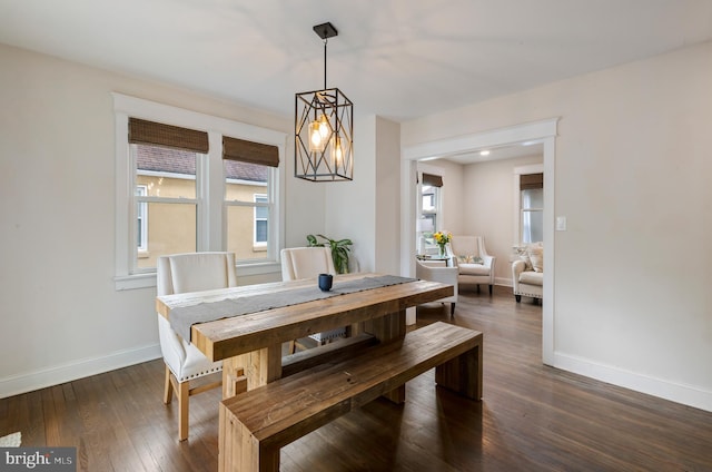 dining space featuring baseboards, dark wood-type flooring, and a chandelier