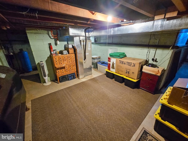 unfinished below grade area featuring a water pressure tank and heating unit