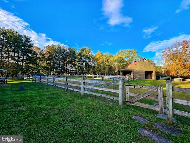 view of green lawn with an outdoor structure, an exterior structure, a barn, and a rural view