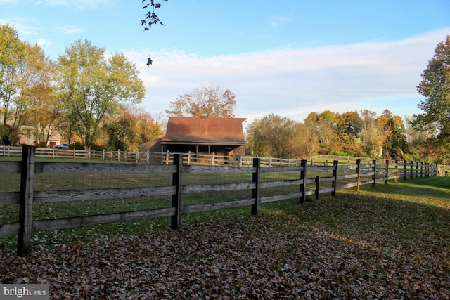 view of yard with an outbuilding, an exterior structure, and a view of rural / pastoral area