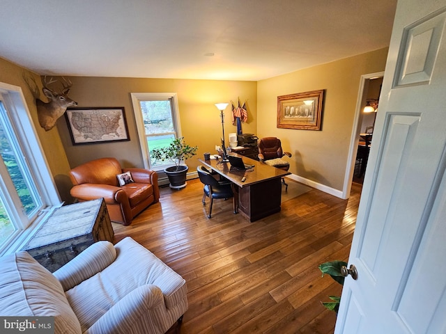 home office featuring wood-type flooring, a baseboard radiator, and baseboards