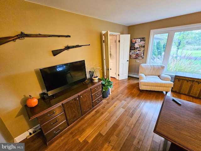 living room with hardwood / wood-style floors and a baseboard heating unit