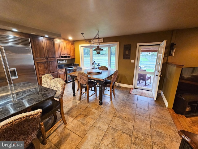 dining space featuring baseboards, recessed lighting, stone tile floors, and wine cooler