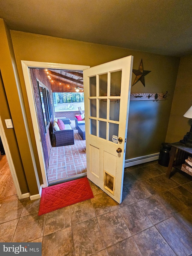 doorway to outside featuring a baseboard radiator and baseboards