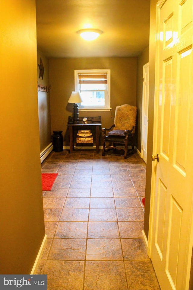 hallway with a baseboard radiator and baseboards