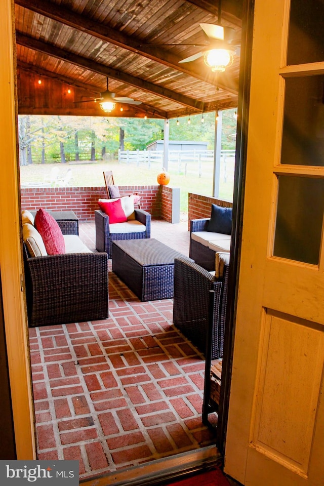 sunroom / solarium with a ceiling fan and an outdoor living space