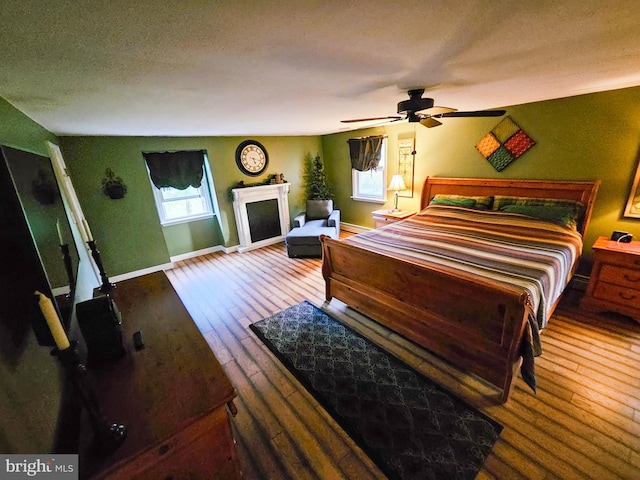 bedroom featuring hardwood / wood-style floors, baseboards, and a textured ceiling