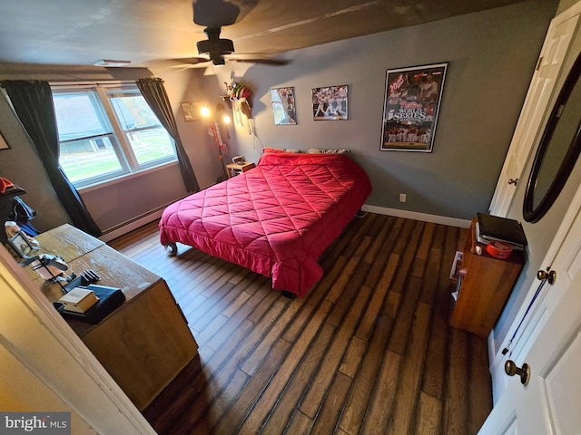 bedroom with a baseboard radiator, wood finished floors, and baseboards