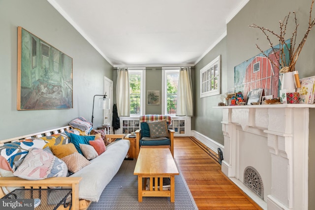 living area featuring crown molding, wood finished floors, and baseboards