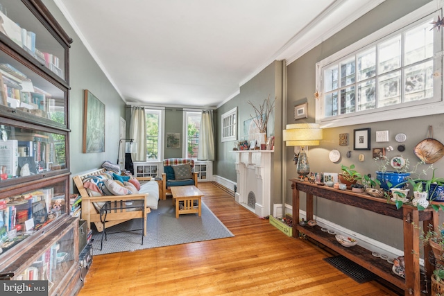 sitting room with crown molding, wood finished floors, and baseboards