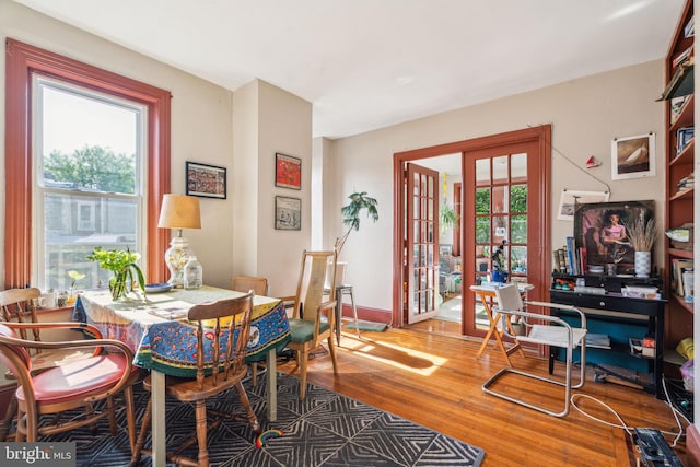 dining room featuring wood finished floors, french doors, and baseboards