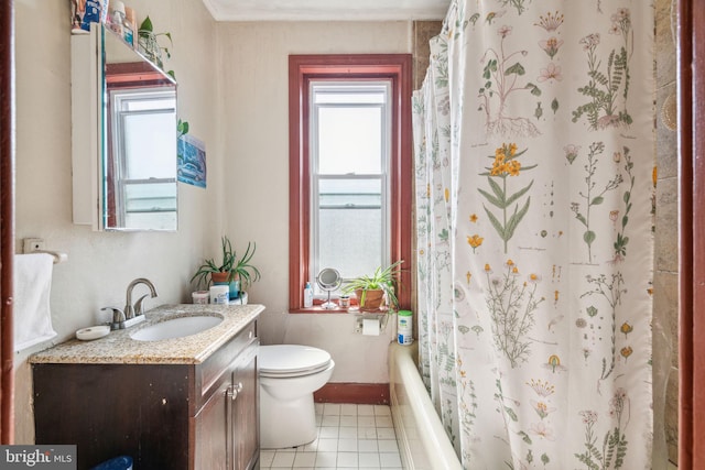 bathroom featuring plenty of natural light, baseboards, vanity, and toilet