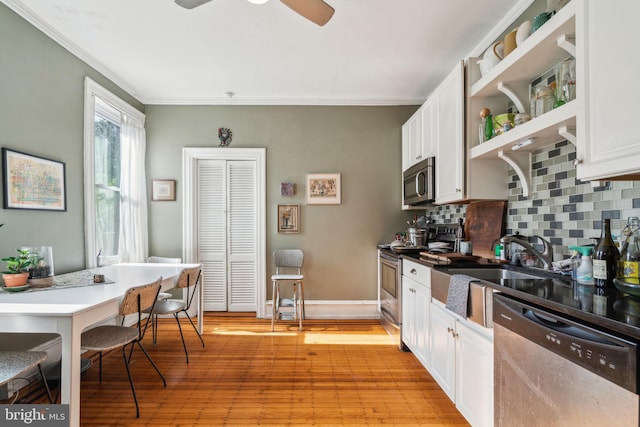 kitchen featuring appliances with stainless steel finishes, open shelves, tasteful backsplash, crown molding, and white cabinets