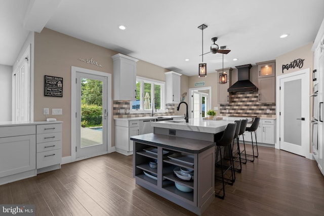 36 Boone Trl, Severna Park, MD 21146 - kitchen featuring wall chimney exhaust hood, tasteful backsplash, a kitchen bar, a kitchen island with sink, and recessed lighting