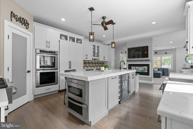 36 Boone Trl, Severna Park, MD 21146 - kitchen featuring beverage cooler, a ceiling fan, stainless steel double oven, open floor plan, and white cabinets