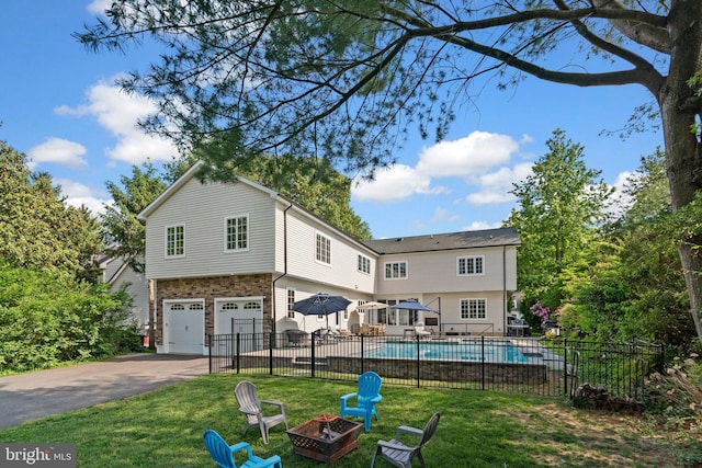 36 Boone Trl, Severna Park, MD 21146 - back of house with an outdoor fire pit, concrete driveway, and a garage