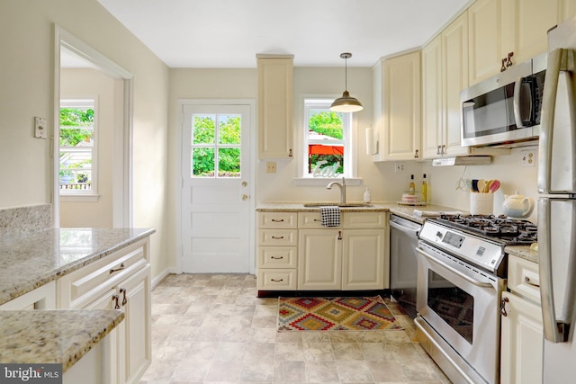 1807 N Barton St, Arlington, VA 22201 - kitchen featuring appliances with stainless steel finishes, a sink, healthy amount of natural light, and light stone countertops