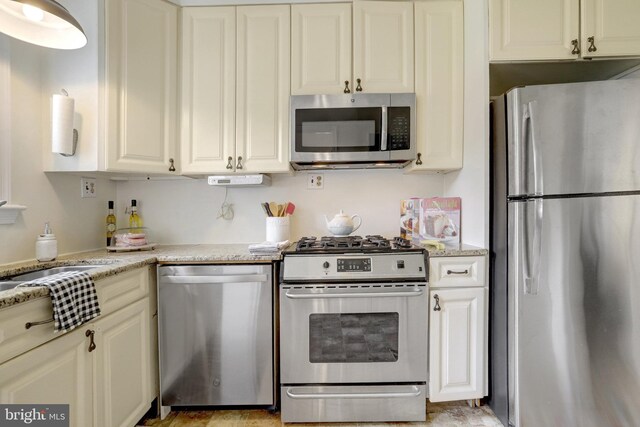 1807 N Barton St, Arlington, VA 22201 - kitchen featuring appliances with stainless steel finishes, light stone counters, white cabinets, and a sink
