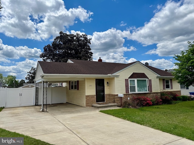 ranch-style home with a gate, an attached carport, concrete driveway, roof with shingles, and stone siding