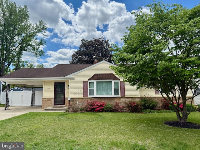 ranch-style house with a gate, driveway, an attached carport, and a shingled roof