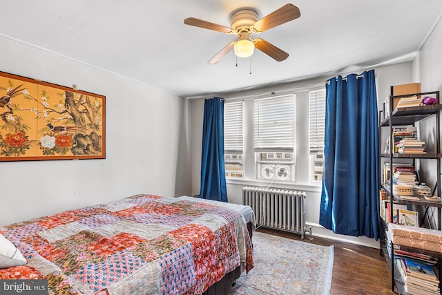 bedroom featuring radiator heating unit, wood finished floors, and ceiling fan