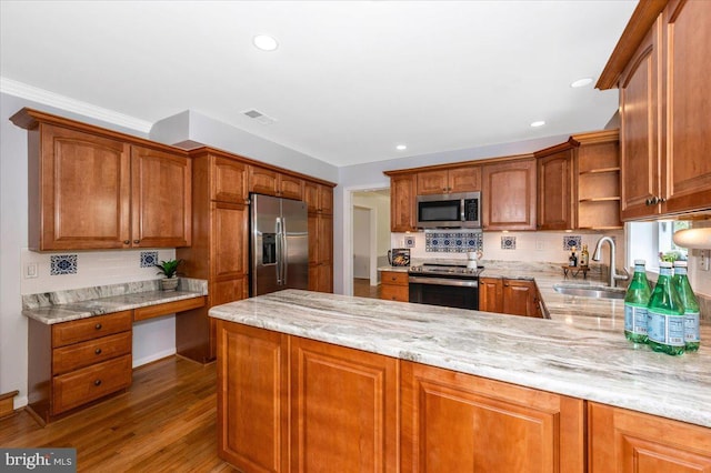 kitchen with appliances with stainless steel finishes, a sink, open shelves, a peninsula, and light stone counters