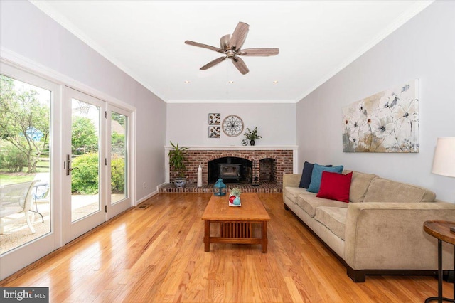 living area featuring light wood-style flooring, a ceiling fan, and crown molding
