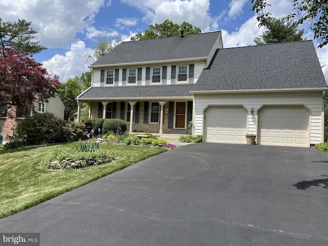 view of front of house with an attached garage, driveway, roof with shingles, a front lawn, and a porch