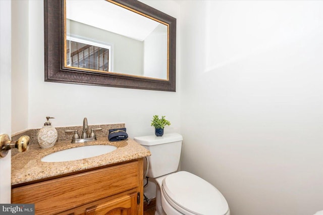 half bathroom with toilet and vanity