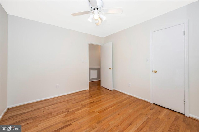 unfurnished bedroom with wood finished floors, baseboards, and a ceiling fan