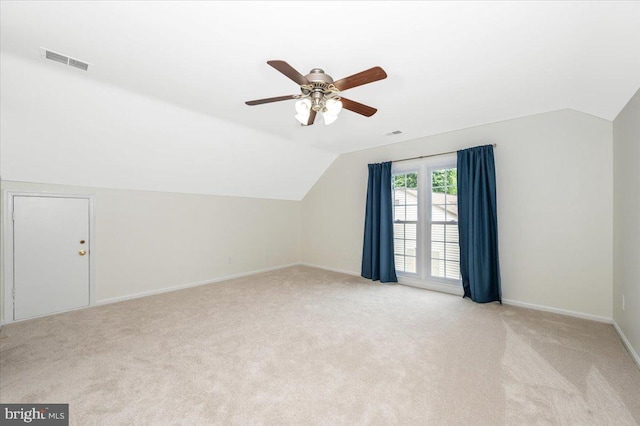 additional living space featuring lofted ceiling, a ceiling fan, light carpet, and baseboards