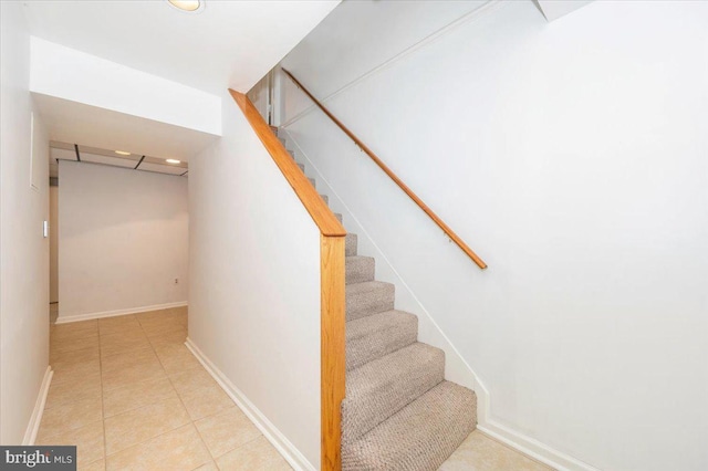 stairway featuring tile patterned flooring and baseboards