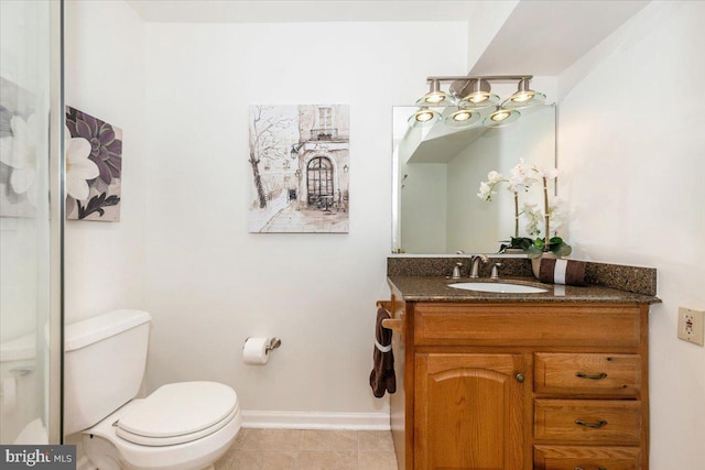 bathroom featuring toilet, vanity, baseboards, and tile patterned floors