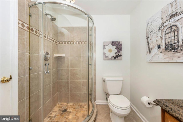 bathroom with a stall shower, toilet, baseboards, and tile patterned floors