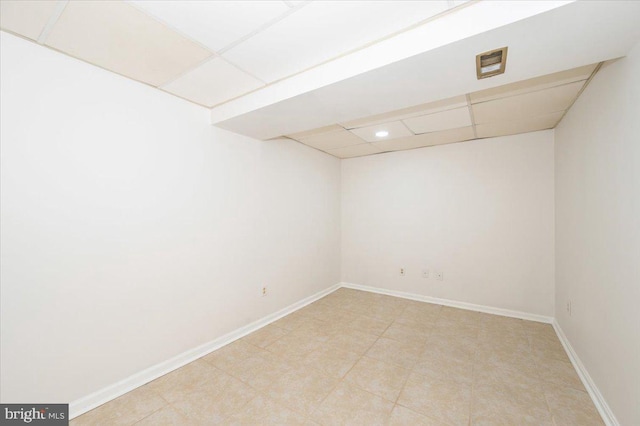 unfurnished room featuring a drop ceiling, baseboards, and recessed lighting