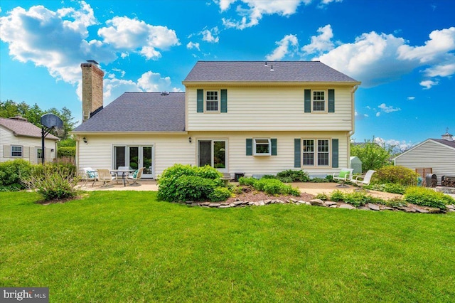 back of house featuring a patio, a yard, and a chimney