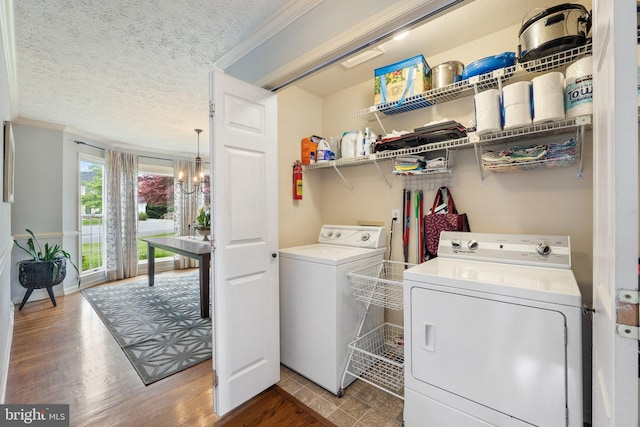 washroom with independent washer and dryer, a chandelier, crown molding, wood finished floors, and a textured ceiling
