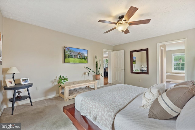 bedroom featuring light colored carpet, baseboards, a textured ceiling, and a ceiling fan