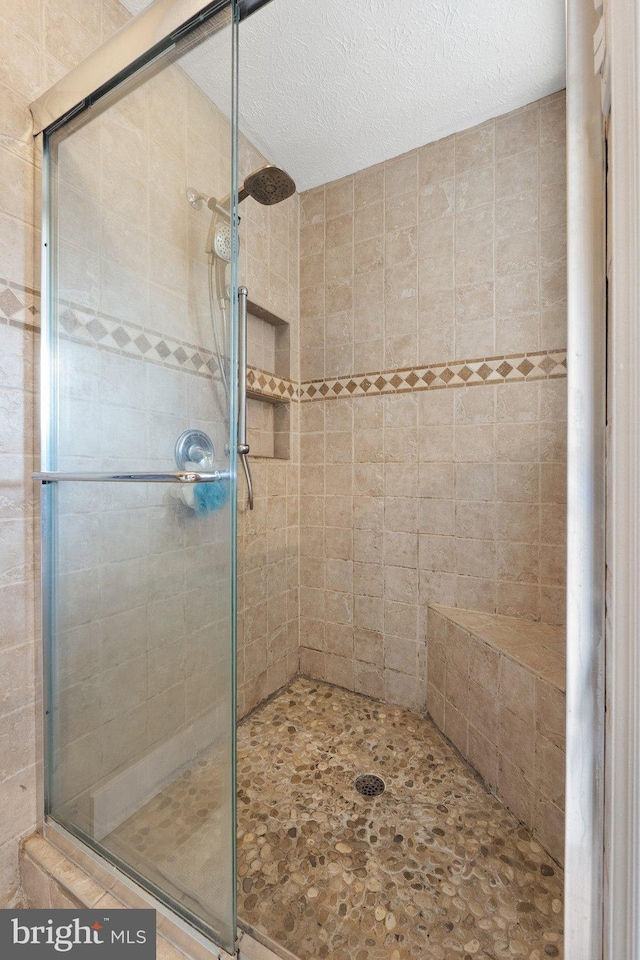 bathroom featuring a stall shower and a textured ceiling