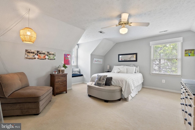 carpeted bedroom featuring vaulted ceiling, a ceiling fan, multiple windows, a textured ceiling, and baseboards